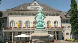 Das &ldquo;Gasthaus zur Margarethenh&ouml;he&rdquo; ist eins der ersten Geb&auml;ude der Siedlung, die zwischen 1909 und 1938 erbaut wurde. Heute beherbergt es ein Hotel und geh&ouml;rt zu den meistfotografierten Motiven des Stadtteils. Im Vordergrund der &bdquo;Schatzgr&auml;berbrunnen&ldquo;, ein Geschenk der Stadt Essen an die Stifterin Margarethe Krupp.