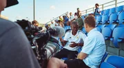 Thomas Hitzlsperger (re.) trifft den Pr&auml;sidenten des Fu&szlig;ballverbands von Cura&ccedil;ao, Gilbert Martina, bei einem Ligaspiel vor Ort.
