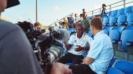 Thomas Hitzlsperger (re.) trifft den Pr&auml;sidenten des Fu&szlig;ballverbands von Cura&ccedil;ao, Gilbert Martina, bei einem Ligaspiel vor Ort.