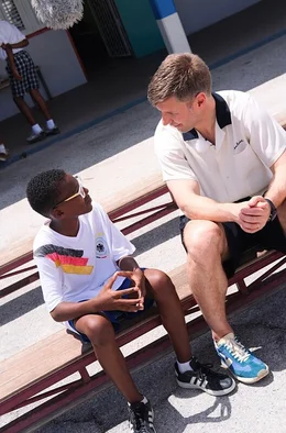 Thomas Hitzlsperger (re.) spricht mit einem Sch&uuml;ler aus Cura&ccedil;ao &uuml;ber die Vorfreude auf die WM.