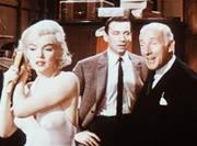 Jean-Marc Clements (Yves Montand, M.) Anwalt John Wales (Wilfried Hyde-White, r.) wei&szlig; nicht so recht, was er von der T&auml;nzerin Amanda (Marilyn Monroe, l.) halten soll. Er macht sich eher Sorgen um das Verm&ouml;gen seines Klienten ...