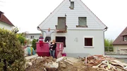 Anja und Alex mit den beiden Kindern vor ihrem Schn&auml;ppchenhaus.