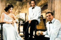 Nach ihrer &uuml;berst&uuml;rzten Hochzeit entdeckt Ruth (Elizabeth Taylor, li.) auf Sri Lanka neue Seiten an ihrem Mann John (Peter Finch, Mi.), die ihr absolut nicht gefallen, und f&uuml;hlt sich zu dem Plantagen-Aufseher Dick (Dana Andrews, re.) hingezogen.