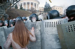 Kiew, Ukraine, Februar 2014: Eine Demonstrantin betet mit der Hand auf dem Schild eines Polizisten vor einer Barrikade auf dem Unabh&auml;ngigkeitsplatz.