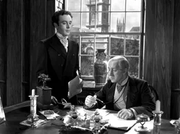 Louis Mazzini (Dennis Price, li.) arbeitet f&uuml;r den liebensw&uuml;rdigen Bankier (Alec Guiness), einer der wenigen aus der Familie, die eines nat&uuml;rlichen Todes sterben.