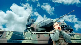 Christina (Christian Clau&szlig;) vor einem Panzer.