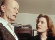 Scully (Gillian Anderson, r.) erfährt von Commander Johansen (Robert Clothier, l.), dass er einer der wenigen Überlebenden eines amerikanischen U-Bootes ist, dessen Besatzung am Ende des Zweiten Weltkriegs ein amerikanisches Jagdflugzeug heben sollte und dann schwere Strahlungsverbrennungen erlitt. Scully (Gillian Anderson, r.) erfährt von Commander Johansen (Robert Clothier, l.), dass er einer der wenigen Überlebenden eines amerikanischen U-Bootes ist, dessen Besatzung am Ende des Zweiten Weltkriegs ein amerikanisches Jagdflugzeug heben sollte und dann schwere Strahlungsverbrennungen erlitt.