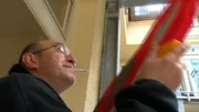 Ein Anwohner vertreibt Tauben mit einer Wasserpistole. Ein Anwohner vertreibt Tauben mit einer Wasserpistole.