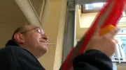 Ein Anwohner vertreibt Tauben mit einer Wasserpistole.