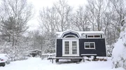 Snow flurries gently fall to the ground and cover Jesse and Nora's completed tiny house and traveling theater, on a blustery winter day, in Richmond, Rhode Island, as seen on Tiny House, Big Living Snow flurries gently fall to the ground and cover Jesse and Nora's completed tiny house and traveling theater, on a blustery winter day, in Richmond, Rhode Island, as seen on Tiny House, Big Living