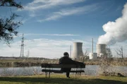 Horst Diepenbruck sitzend am See, im Hintergrund das laufende Atomkraftwerk Gundremmingen