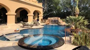 The top-tier of the Larson pool is complete with an oversize spillway spa, Baja shelf, waterfall, grotto, infinity edge, and ample entertaining space on a travertine deck. The top-tier of the Larson pool is complete with an oversize spillway spa, Baja shelf, waterfall, grotto, infinity edge, and ample entertaining space on a travertine deck.