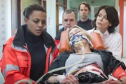 Helen (Dennenesch Zoud&eacute;, l.) ist geschockt. Melanie (Sanna Englund, 2.v.r.) wurde mit Mattes' (Matthias Schloo, M.) Dienstwaffe angeschossen. Werden Jasmin (Gerit Kling, r.) und sie es schaffen, Melanie zu retten?