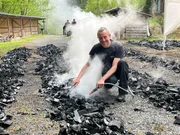 Björn Stumpf, Köhler beim Frankenwaldverein, löscht glimmende Holzkohle ab. Björn Stumpf, Köhler beim Frankenwaldverein, löscht glimmende Holzkohle ab.
