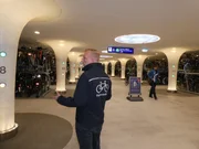 Mike steht mit dem R&uuml;cken zur Kamera bei den Fahrradst&auml;ndern im Hauptgang des Parkhauses.