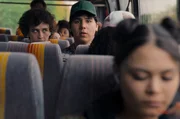 Ben (Shadi Eck, l.) und Janni (Diyar Ilhan, M.) sitzen im Bus auf dem Weg zum Demokratie-Camp und beobachten Suki (Tomomi Themann, r.), die zwei Reihen vor ihnen sitzt. Im Bus sitzen weitere Mitsch&uuml;ler (Komparsen).