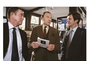 Barnaby (John Nettles, l.) und sein Assistent Jones (Jason Hughes, r.) zeigen Heimatmuseumsdirektor Giles Cato (Michael Elwyn, M.) eine Grusel-Brosch&uuml;re &uuml;ber Spukh&auml;user in Midsomer.