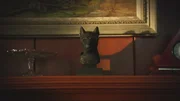 B&uuml;ste der alt&auml;gyptischen G&ouml;ttin Bastet in Form einer Katze, platziert auf einer Holzkommode vor einem gerahmten Kunstgem&auml;lde.