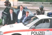 "Kommissar Rex", "Der Mann mit den tausend Gesichtern." Eine Serie von &Uuml;berf&auml;llen auf Superm&auml;rkte und Banken besch&auml;ftigen den neuen Kommissar und sein Team, denn der T&auml;ter f&uuml;hrt seine Raubz&uuml;ge in immer neuen Masken und Verkleidungen durch. Niemand wei&szlig;, wie der Mann tats&auml;chlich aussieht. Doch mit Hilfe von Rex kann Alex Brandtner den T&auml;ter identifizieren und es kommt zu einer wilden Verfolgungsjagd im Zoo von Sch&ouml;nbrunn. Im Bild (v.li.): Gedeon Burkhard (Alexander Brandtner), Wolf Bachofner (Peter H&ouml;llerer), Heinz Weixelbraun (Christian B&ouml;ck).