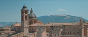 Luftaufnahme des ber&uuml;hmten Palazzo Ducale in Urbino, im Hintergrund die sanften H&uuml;gel der Landschaft.