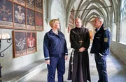 Paul Schott (Tim Wilde, r.) und Nele Fehrenbach (Floriane Daniel, l.) treffen Abt Barnabas (Ulrich Gebauer, M.) im Kreuzgang von Kloster Oberzell. Paul Schott (Tim Wilde, r.) und Nele Fehrenbach (Floriane Daniel, l.) treffen Abt Barnabas (Ulrich Gebauer, M.) im Kreuzgang von Kloster Oberzell.