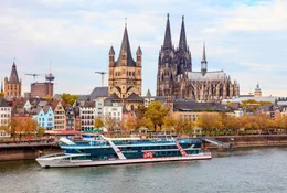 Das Ausflugsschiff RheinFantasie der KD K&ouml;ln D&uuml;sseldorfer liegt in K&ouml;ln vor der Kulisse der Altstadt mit K&ouml;lner Dom (r) und der romanischen Kirche Gro&szlig; St. Martin.