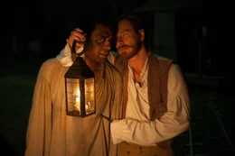 Der sadistische Plantagenbesitzer und Sklaventreiber Edwin Epps (Michael Fassbender, r.) bezeichnet sich selbst als "Nigger Brecher", einen Namen, den seine Sklaven, wie der in die Sklaverei verschleppte Solomon (Chiwetel Ejiofor, l.), am eigenen Leib zu sp&uuml;ren bekommen ...