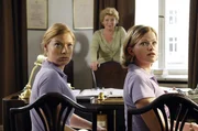 Soeben hat Frau Dr. Westphal (Peggy Lukac, M.) Lisa (Mira Bartuschek, r.) und Nicki (Britta Horn, l.) mitgeteilt, dass ab sofort ihr Neffe Dr. Luka Schneider die Arztpraxis &uuml;bernimmt und ihr neuer Chef wird.