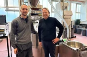 Bj&ouml;rn Freitag (r.) lernt von R&ouml;ster Tillman Hoheisel (l.), worauf es bei der R&ouml;stung von Kaffeebohnen ankommt.
