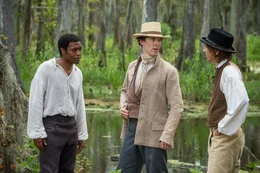 Der freie Afroamerikaner Solomon (Chiwetel Ejiofor, l.) wird von zwei M&auml;nnern entf&uuml;hrt und in die Sklaverei verkauft. Zuerst landet er bei dem vergleichsweise friedfertigen Sklaventreiber William Ford (Michael Fassbender, M.), erweckt dort aber die Missgunst des eifers&uuml;chtigen Aufsehers John Tibeats (Paul Dano, r.) und wird deswegen an den sadistischen Plantagenbesitzer Edwin Epps verkauft ...