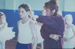 Als Billy (Jamie Bell, l.) - auf Dr&auml;ngen des Vaters - beim Boxunterricht ist, zieht in der benachbarten Turnhalle die Balletttruppe von Mrs. Wilkinson (Julie Walters, r.) ein, die ihn zum Mitmachen auffordert. Als er Begeisterung und Talent daf&uuml;r entdeckt, macht er nun regelm&auml;&szlig;ig statt des Boxtrainings heimlich beim Tanzunterricht mit ...