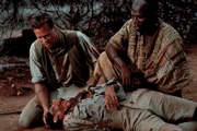 Entsetzt m&uuml;ssen Patterson (Val Kilmer, l.) und Samuel (John Kani, r.) entdecken, dass auch Starling (Brian McCardie, liegend) einer L&ouml;wenattacke zum Opfer gefallen ist ...