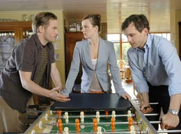 Thomas (Ole Puppe, re.), Elke (Annika Kuhl) und ihr Mann Sebastian (Wanja Mues) &uuml;berlegen, wie man ihre zertrittenen Eltern endlich zur Vernunft bringen k&ouml;nnte.