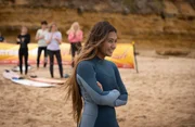 Poppy (Lilliana Bowrey, v.) feuert Ari, für den sie schwärmt, beim Surf-Wettkampf in Jackson Bay an. Poppy (Lilliana Bowrey, v.) feuert Ari, für den sie schwärmt, beim Surf-Wettkampf in Jackson Bay an.