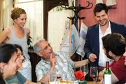 Als Nina (Maria Wedig, stehend l.) sich beim Kellnern in der Goldelse einem unerwarteten Besucheransturm ausgesetzt sieht, bittet sie Stefan (Manuel Cortez, stehend r.) um Hilfe. Gemeinsam gelingt es ihnen, die Situation zu bew&auml;ltigen ...