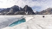 The team walk past a huge meltwater lake on the Edward Bailey Glacier.