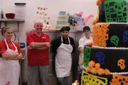 The crew looks on at the finished Day of the Dead cake. The crew looks on at the finished Day of the Dead cake.