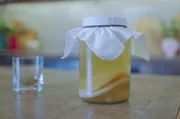 Lucie f&uuml;llt das Scobywasser in ein Glas um &ndash; der Kombucha kann jetzt gew&uuml;rzt werden.