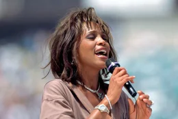 Egal ob Liverpooler oder Dortmunder Fans zu "You'll Never Walk Alone" ihre bunten Fanschals im Stadion schwenken, Henry Maske bei seinem Abschiedskampf zu den epochalen Kl&auml;ngen von "Time To Say Goodbye" einmarschiert oder Whitney Houston (Foto) mit "One Moment In Time" die emotionalsten Momente der Olympischen Spiele besingt: Gro&szlig;e Sporthymnen schaffen ein Gef&uuml;hl von Gemeinschaft, verursachen G&auml;nsehautmomente oder laden einfach nur zum kollektiven Mitgr&ouml;len ein. (Archivfoto: Whitney Houston, Auftritt w&auml;hrend Er&ouml;ffnungsfeier der Fu&szlig;ball WM 1994, Los Angeles)