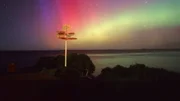 Dieses Bild zeigt den berühmten leuchtend gelben Wegweiser am Stirling Point in Bluff, Neuseeland, vor dem Hintergrund eines beeindruckenden Schauspiels der Aurora Australis (Südlichter). Dieses Bild zeigt den berühmten leuchtend gelben Wegweiser am Stirling Point in Bluff, Neuseeland, vor dem Hintergrund eines beeindruckenden Schauspiels der Aurora Australis (Südlichter).