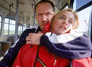 J&ouml;rg (R. Viktor Minich) h&auml;lt mit einer Hand seine Geisel Karin Thaler (Roswitha Meyer) auf seinem Schoss fest und lenkt mit der anderen Hand den Fluchtbus...