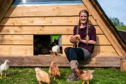 Shekinah Fuchs beim Hühnerstall mit einem Huhn auf dem Arm. Shekinah Fuchs beim Hühnerstall mit einem Huhn auf dem Arm.