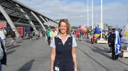 Alexandra steht hinter dem Amsterdamer Hauptbahnhof, im Hintergrund sind Fahnentr&auml;ger zu sehen.