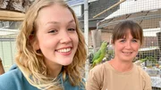 Nina (links) besucht Michelle in ihrer Vogelauffangstation, wo sie verletzte Vögel versorgt. Halsbandsittich Lefou ist besonders zutraulich. (Michelle Engels). Nina (links) besucht Michelle in ihrer Vogelauffangstation, wo sie verletzte Vögel versorgt. Halsbandsittich Lefou ist besonders zutraulich. (Michelle Engels).