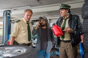 Mike Schulz (Zejhun Demirov, M.) versucht den Besitzer der Tankstelle telefonisch zu erreichen. Hubert (Christian Tramitz, l.) und Staller (Helmfried von L&uuml;ttichau, r.) haben ihn aber schon gefunden - er liegt tot zwischen den Reifen.