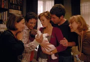 Pilar (Cornelia Schmaus, links) und Elke (Gabi Dohm, rechts) beobachten, wie Kurt (Tim Bergmann, rechts) und Juan (Gunther Gillian) sich gleicherma&szlig;en um Billies (Muriel Baumeister) Kind k&uuml;mmern.