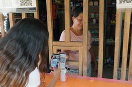 Maria Aguirre (Mi.) akzeptiert in ihrem Stra&szlig;enshop im salvadorianischen Surfer-Dorf El Zonte auch virtuelles Geld. &Uuml;ber eine Smartphone-App nimmt sie Bitcoin an, die erste und &auml;lteste Kryptow&auml;hrung.