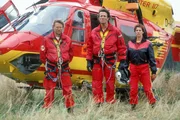 Peter Berger (Serge Falck, li), Dr. Harland (Urs Remond) und Biggi Schwerin (Sabine Petzl) warten vor dem Medicopter auf den vermi&szlig;ten Thomas W&auml;chter. Schafft er es noch fr&uuml;h genug aus dem brennenden Bergwerkstollen zu fliehen?