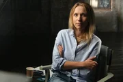 Portr&auml;t einer Frau, die mit verschr&auml;nkten Armen sitzt.