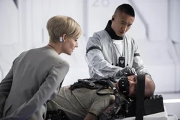 Secretary Delacourt (Jodie Foster, vorne l.) observes Max (Matt Damon, vorne r.)